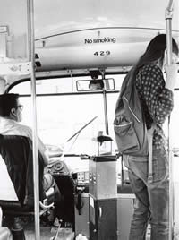 Photograph inside of University of Texas Shuttle Bus showing driver and passenger