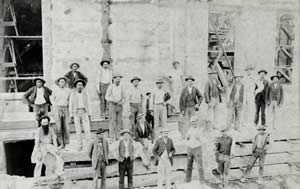 Photograph of workers standing in front of the Capitol under construction