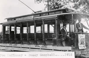 Photograph of open-air electric streetcar with Conductor McKinney and Motorman Campbell in front of car